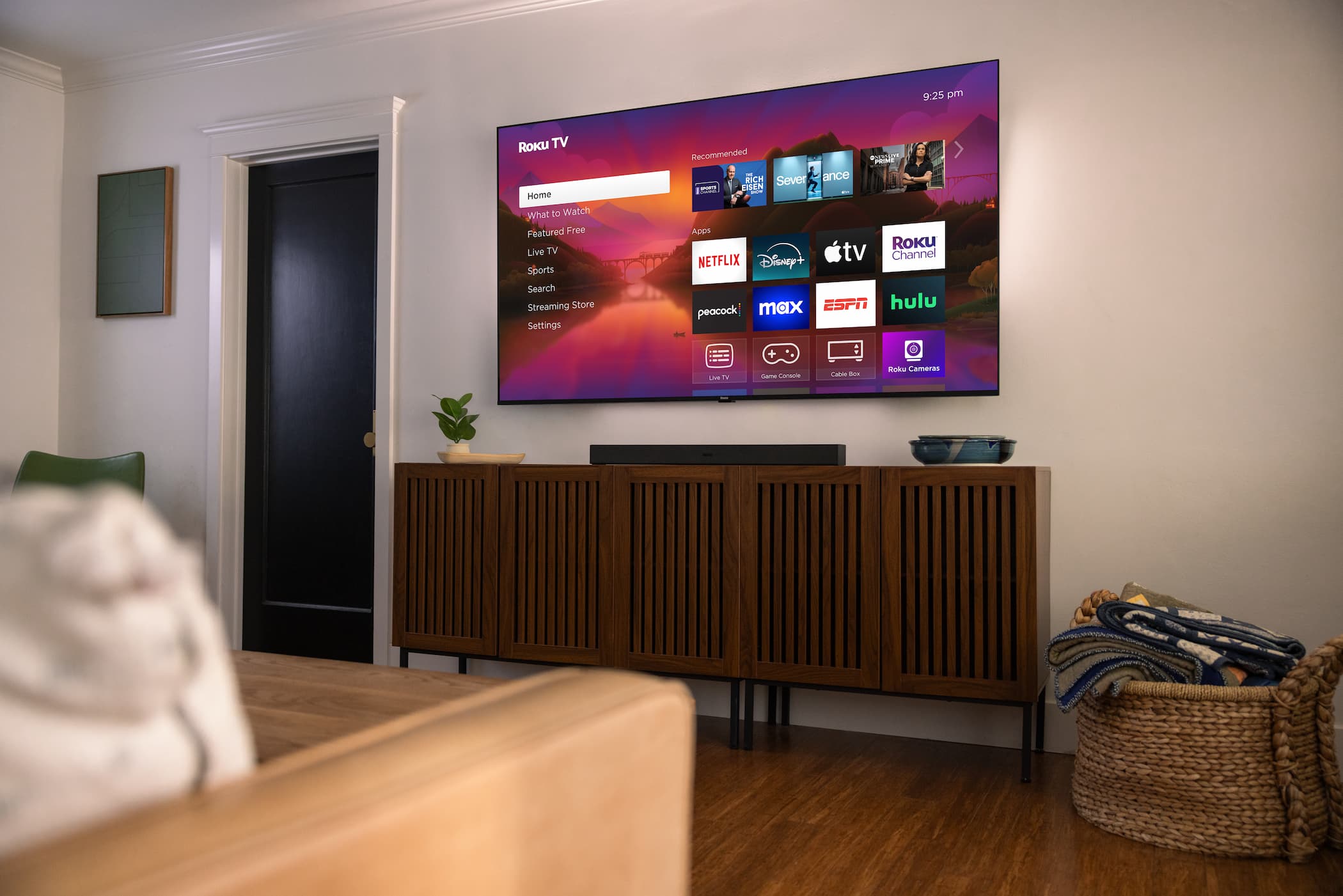 A Roku Plus Series tv mouted on a wall